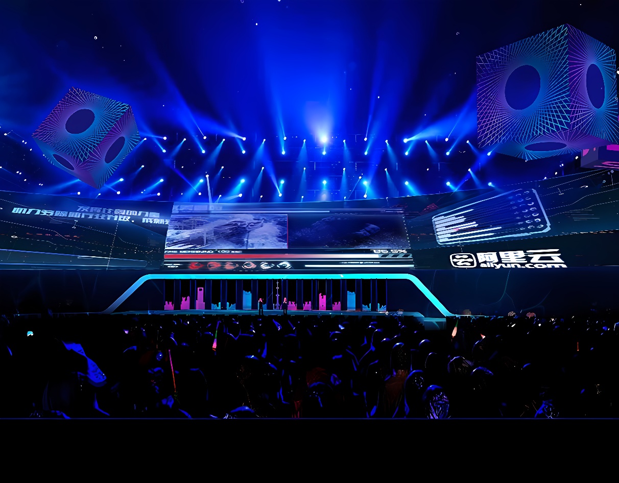 这是一张科技会议的照片，舞台上有演讲台，大屏幕展示信息，现场灯光炫丽，观众席座位排列整齐。