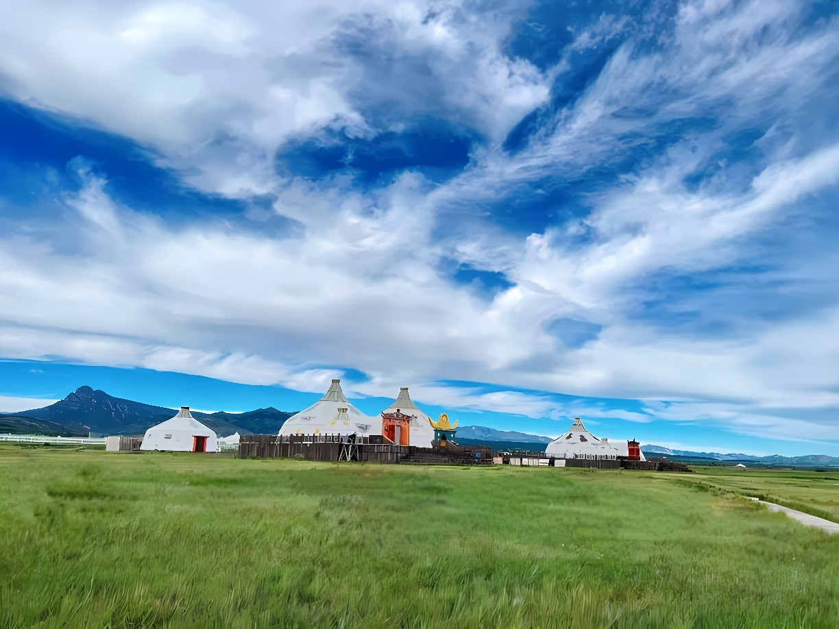 图片展示了一片开阔的草原，蓝天白云下有几顶蒙古包和一座装饰有金色鹿角的建筑，远处是连绵的山脉。