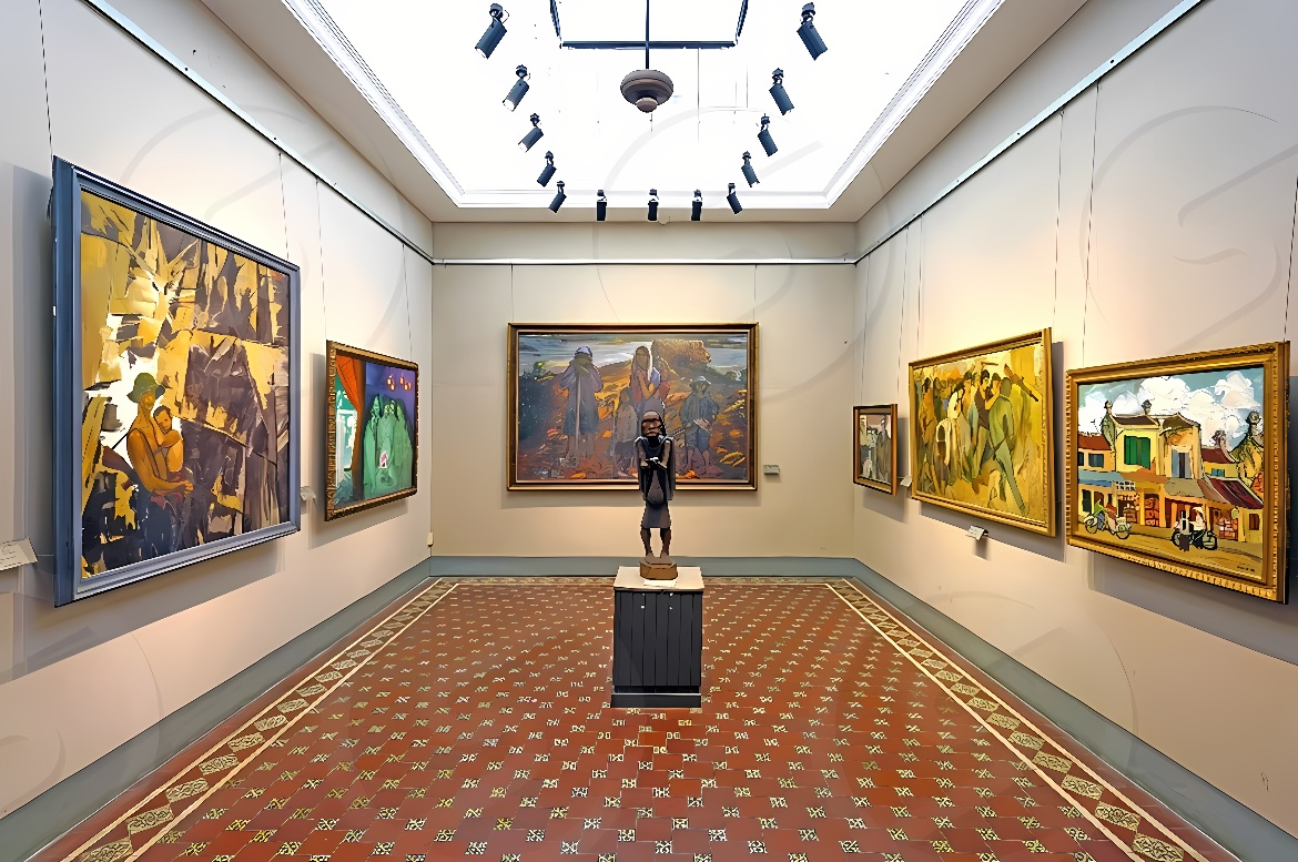 这是一间艺术画廊内部，墙壁上挂满了不同风格的画作，中间放置一座雕塑，地面铺有图案地毯，顶部有吊灯照明。