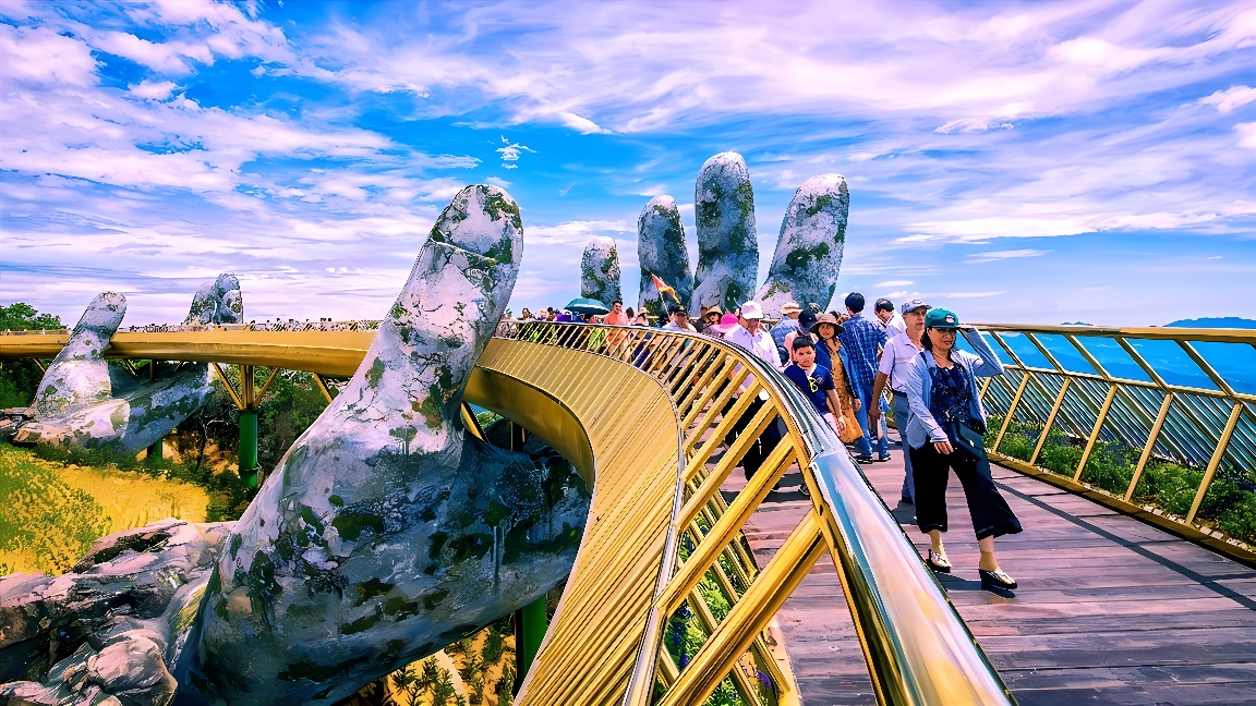 图片展示了一座特色桥梁，桥身由巨大的手支撑，上面有游客行走，背景是晴朗的天空和远处的景色。