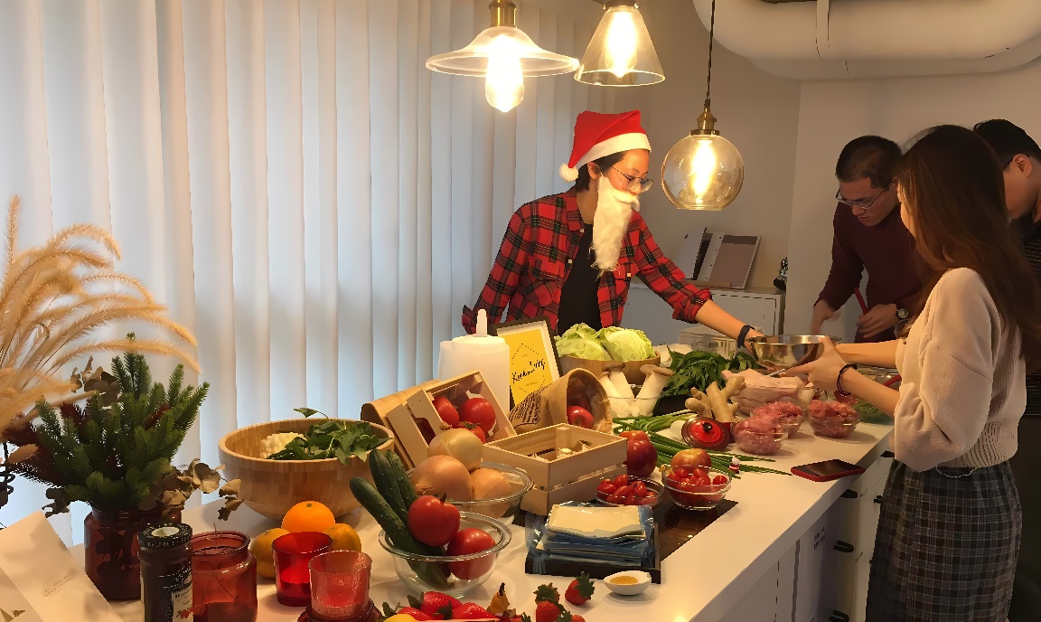 图片展示几人围绕餐桌准备食物，桌上摆满食材。一人戴圣诞帽，氛围温馨，可能是节日聚会。