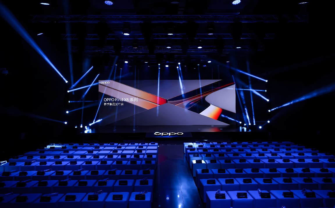 这是一张OPPO品牌活动的照片，展示了舞台、灯光和前方摆放整齐的座椅，场景布置现代且科技感十足。