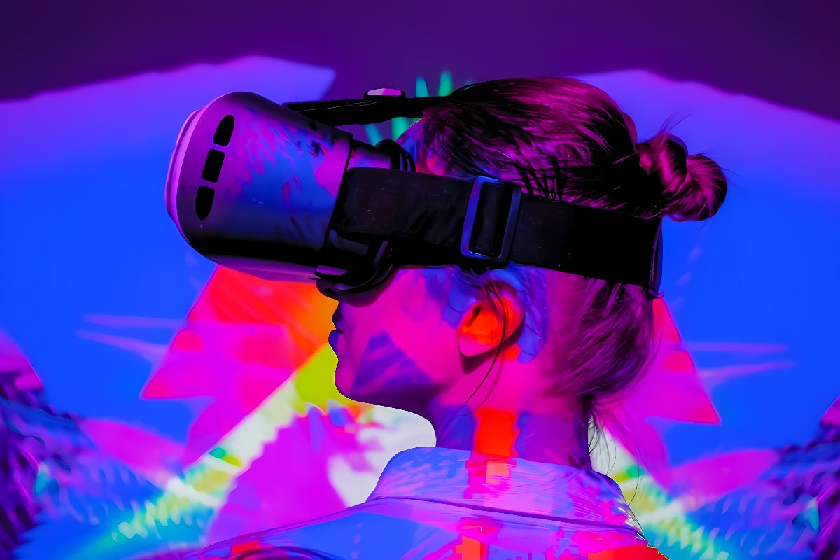 图片展示一位女性戴着虚拟现实头盔，背景为鲜艳的霓虹色调，给人一种科技感和未来主义的视觉体验。