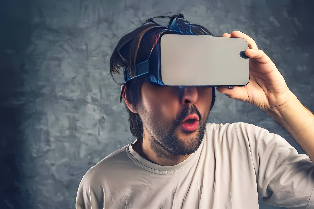 图片展示一位男士戴着虚拟现实头盔，表情惊讶，似乎正在体验虚拟现实世界中的某种刺激内容。背景为灰色墙面。