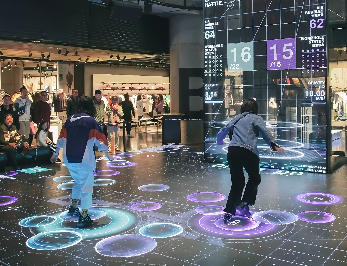 图片展示两人在带有互动显示屏的地面上玩游戏，周围是观众和商店环境。