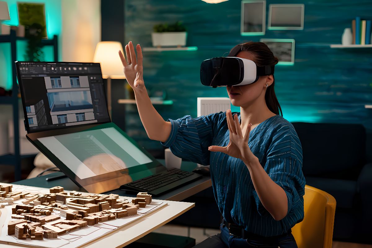 图片展示一位女性正佩戴虚拟现实头盔，似乎在体验或操作虚拟空间，她的桌上摆放着建筑模型和电脑。