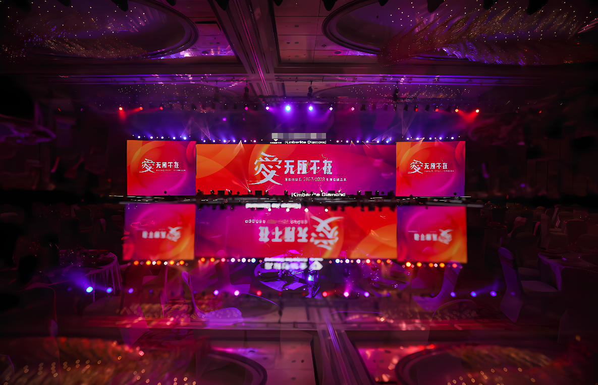 这是一张宴会厅内的照片，有装饰华丽的桌椅和舞台，舞台上有屏幕显示着红色背景的文字。
