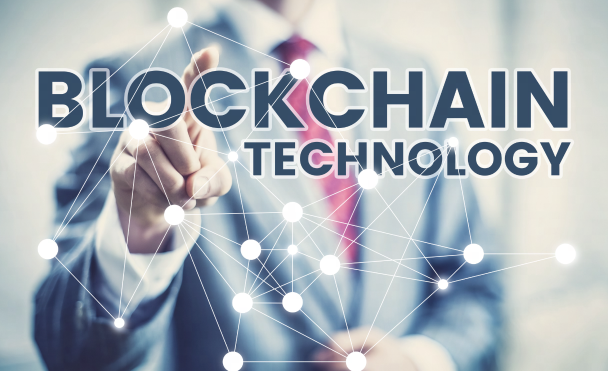 一名身穿正装的人士正触摸虚拟界面，界面上显示“BLOCKCHAIN TECHNOLOGY”字样，代表区块链技术概念。