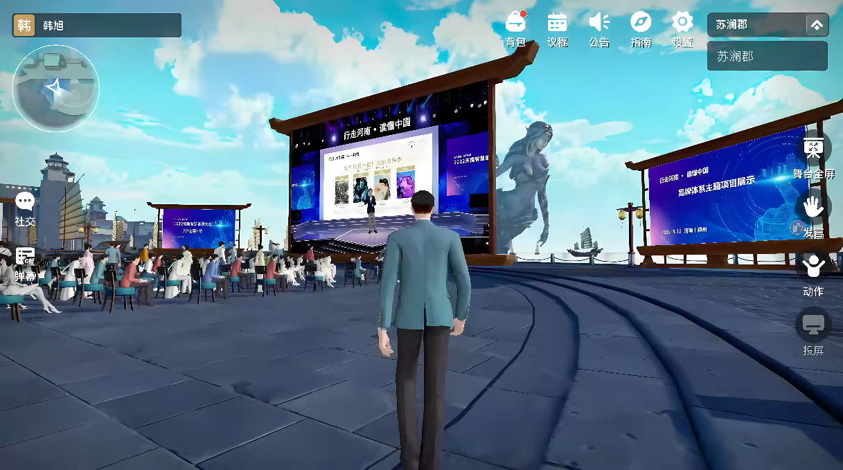 图片展示了一位男性角色站在虚拟现实环境中，前方是一个大屏幕和一群观众，场景看起来像是一个数字会议或活动。