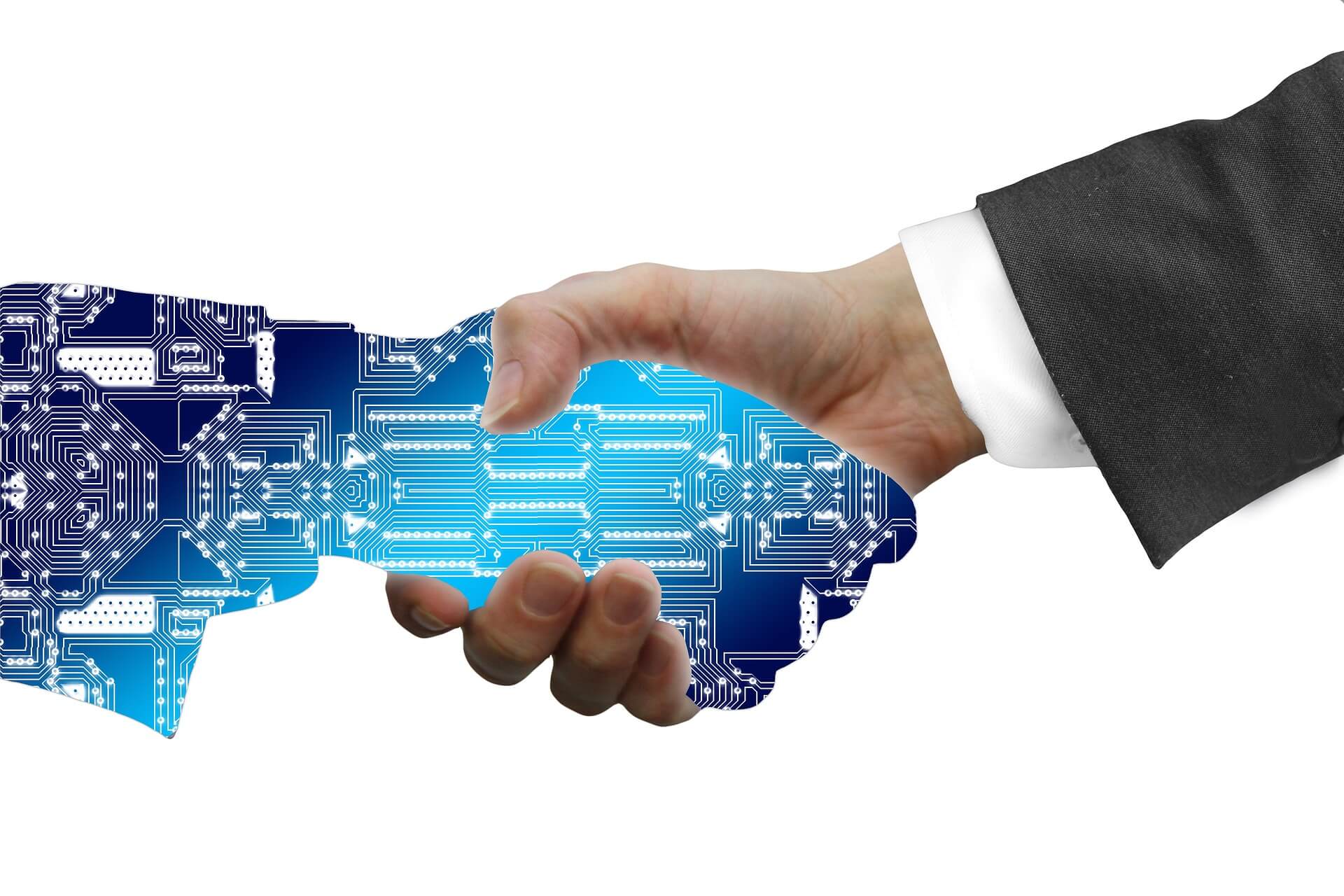 图片展示了一只人类手与一只电子线路板图案的机械手相握，象征着人类与技术的结合。
