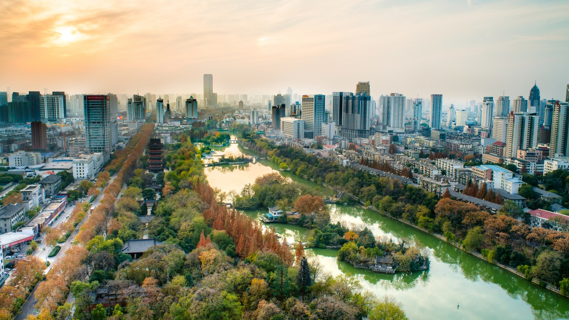 这是一张城市风光照片，展示了高楼大厦与自然景观的和谐共存，天空呈现出黄昏时分的暖色调，整个画面给人以宁静美好的感觉。