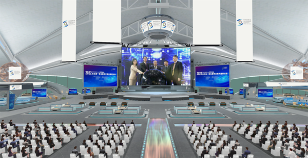 这是一张会议场景的图片，台上有几位发言人，台下坐着众多听众，场馆现代化，装饰以蓝白色调为主。