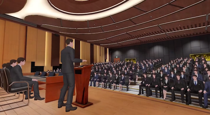 图片展示了一个演讲场景，一位男士站在讲台上，面向着坐满听众的大厅，环境正式，可能是某个会议或讲座。