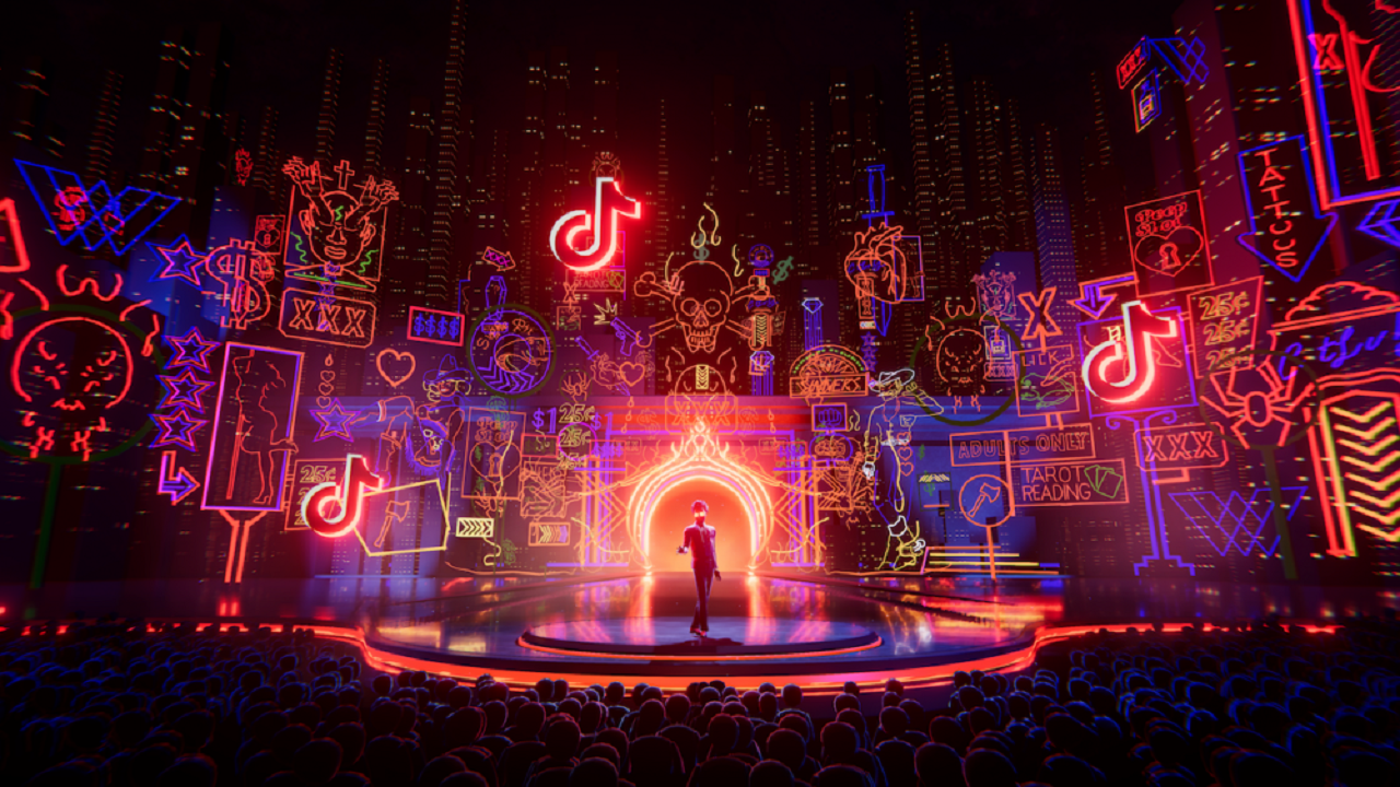 图片展示了一场充满霓虹灯效的现代演出，舞台中央有人物表演，背景是装饰着各种图案和符号的虚拟城市天际线。