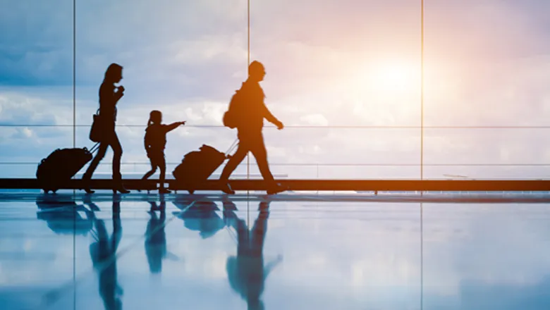 图片展示了一家三口在机场的剪影，他们拖着行李，孩子伸手指向窗外，逆光映衬出他们的轮廓和和谐的氛围。