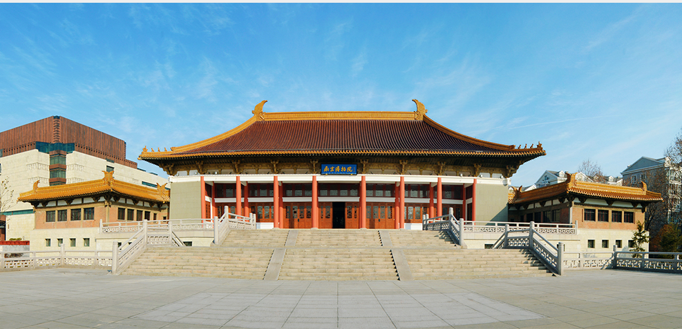 这是一幅展示中国传统建筑的图片，建筑屋顶呈歇山顶式，前有阶梯，蓝天下显得庄严肃穆。