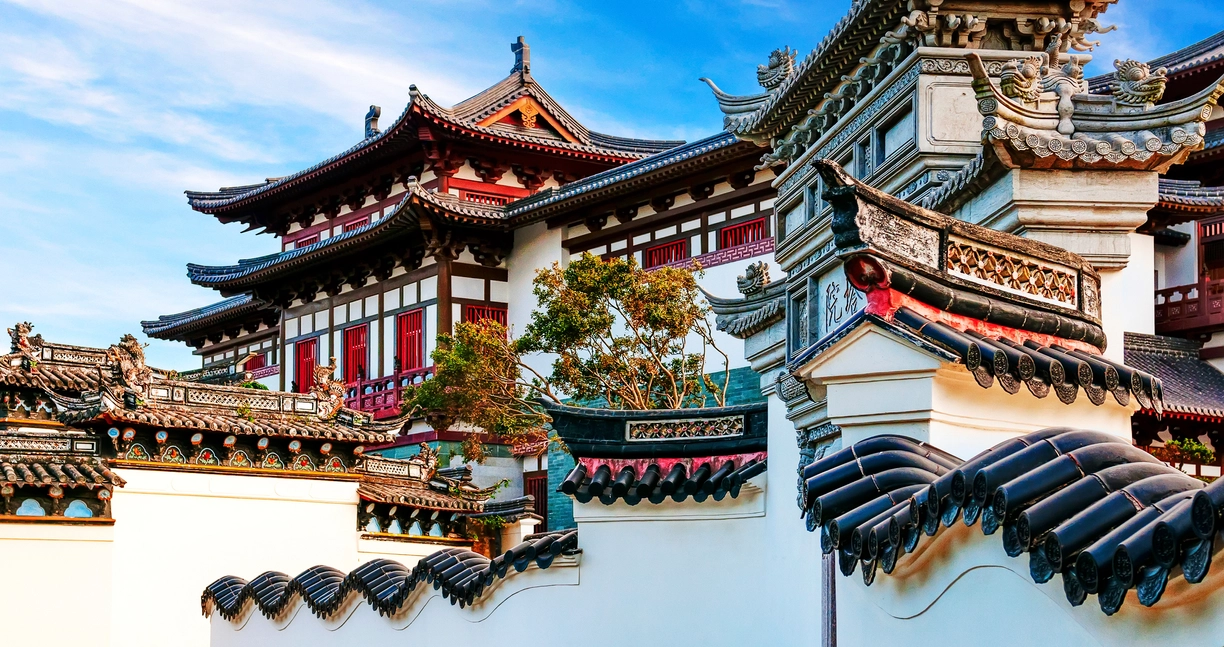 这是一张展示中国传统建筑的图片，有飞檐翘角的屋顶，精美的木雕窗棂，以及典型的红白色调。