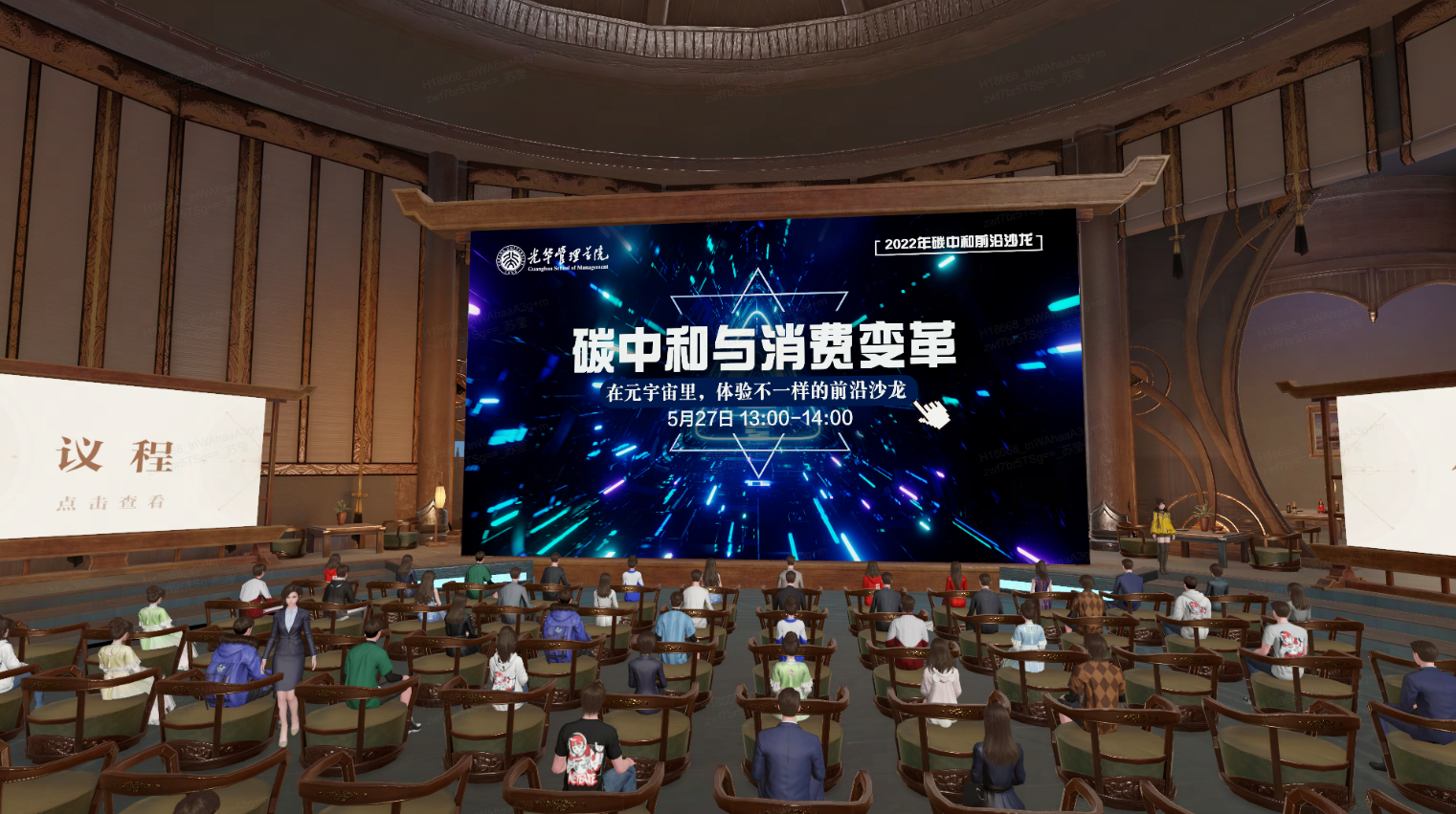图片展示了一个室内场合，人们坐着观看大屏幕，屏幕上有中文文字和图案，似乎是某种活动或会议的现场。