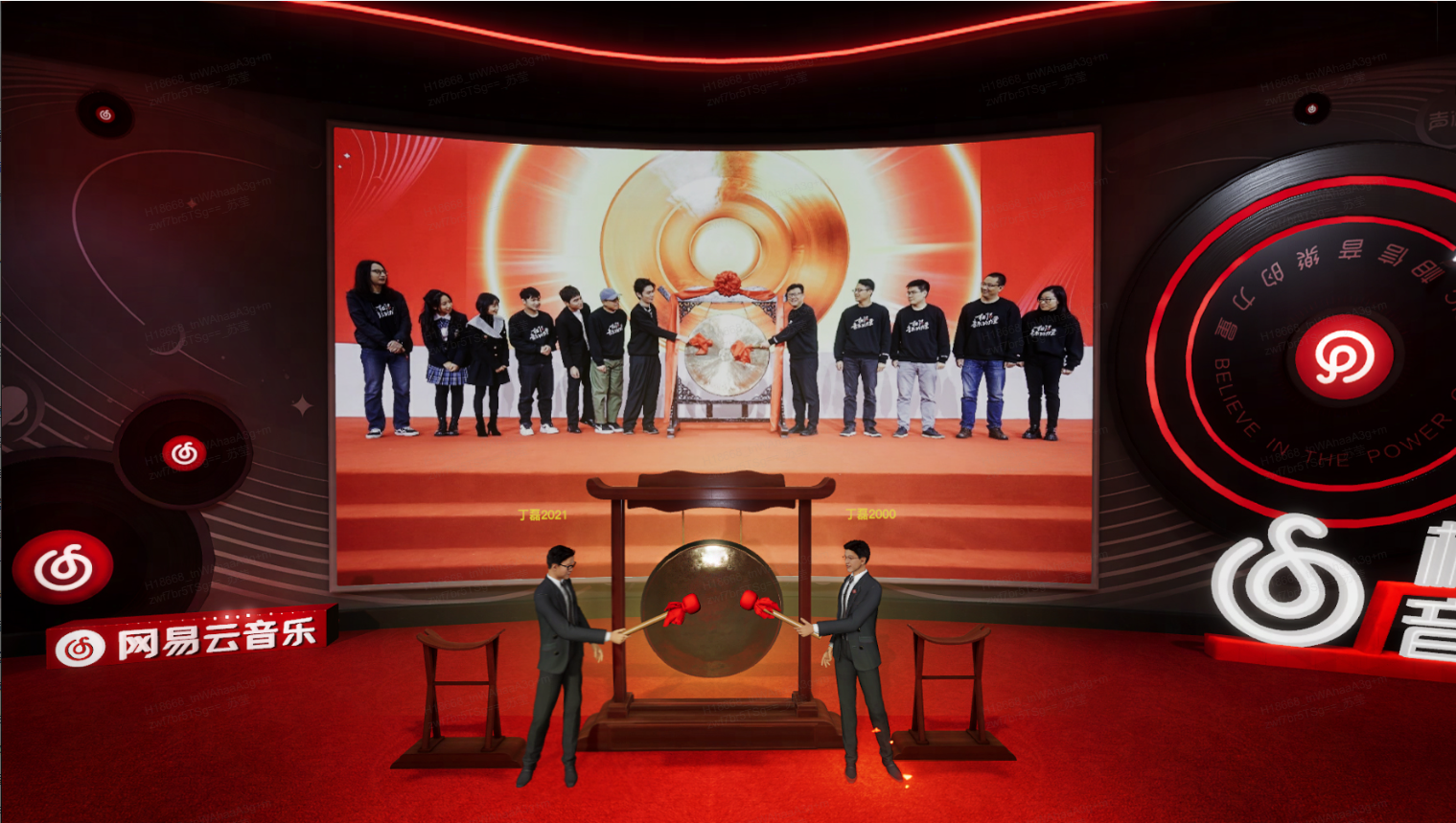图片展示了两位男士站在大屏幕前，屏幕上显示着一组穿着统一服装的人员和中央的标志性图案，周围有红色和黑色的装饰元素。