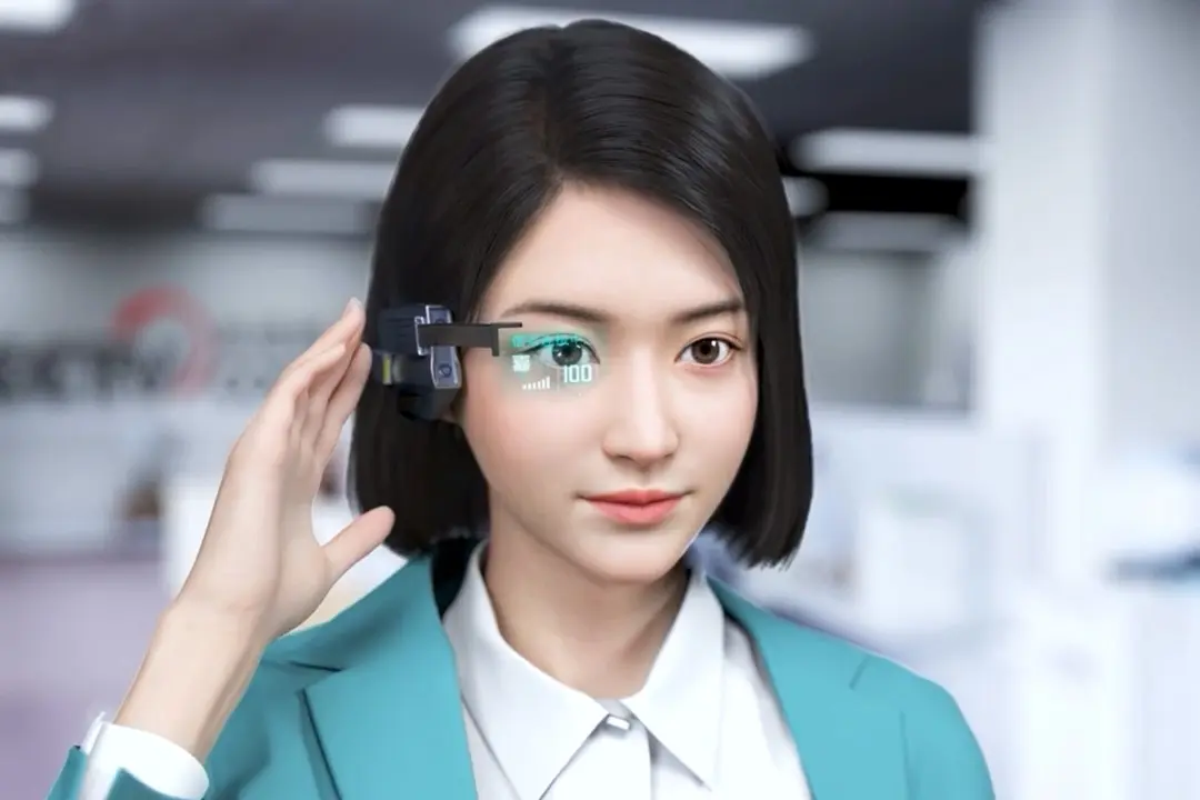 图片展示了一位戴着未来风格眼镜的亚洲女性，眼镜显示数字信息，她身穿蓝色西装，背景似乎是办公室。