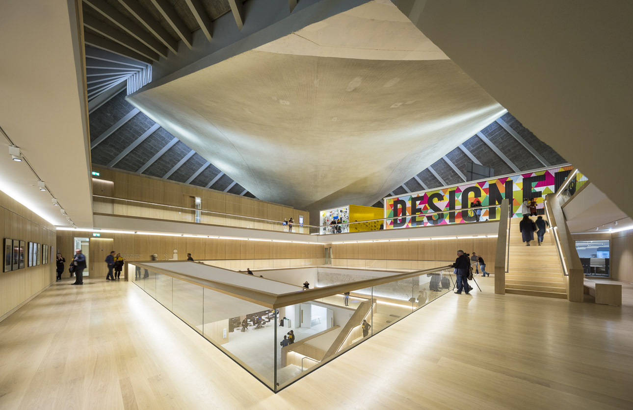 这是一张现代建筑内部的照片，展示了宽敞的多层空间，干净的线条，以及人们在内部活动的场景。