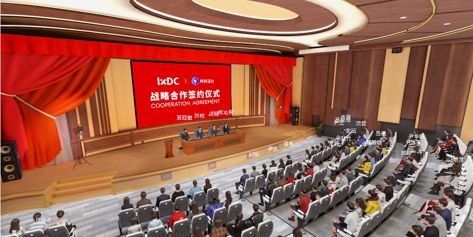 这是一张会议室内的图片，台上有几位演讲者，台下坐满了听众。背景是红色的帷幕和一块写有合作协议字样的横幅。