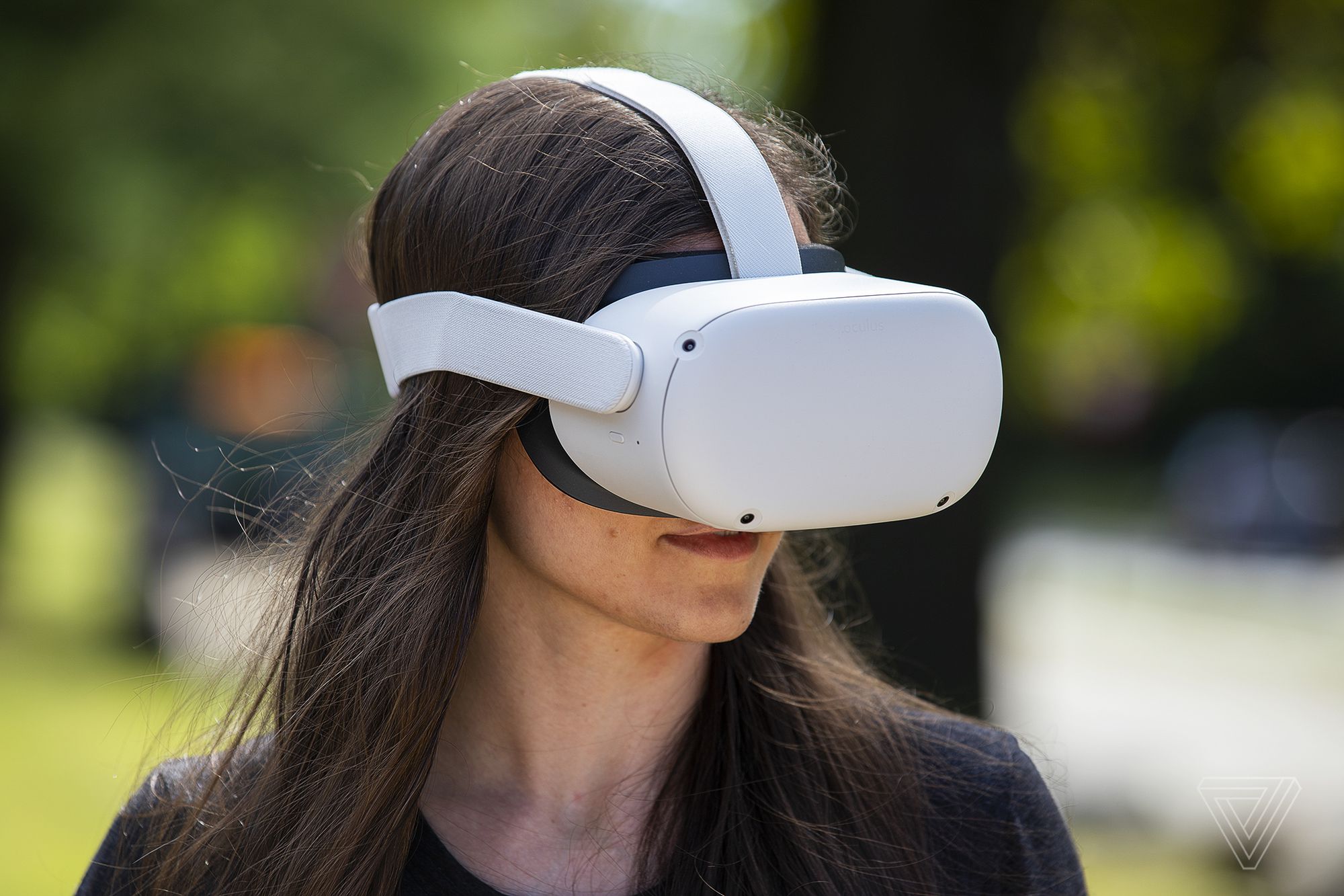图片展示了一位长发女性戴着白色的虚拟现实头盔，似乎正在体验虚拟现实内容。头盔遮住了她的眼睛。