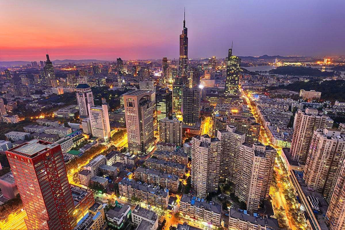 这是一张城市天际线的黄昏照片，高楼大厦错落有致，灯光闪烁，天空呈现出橙紫色渐变，展现了都市的繁华与宁静共存。