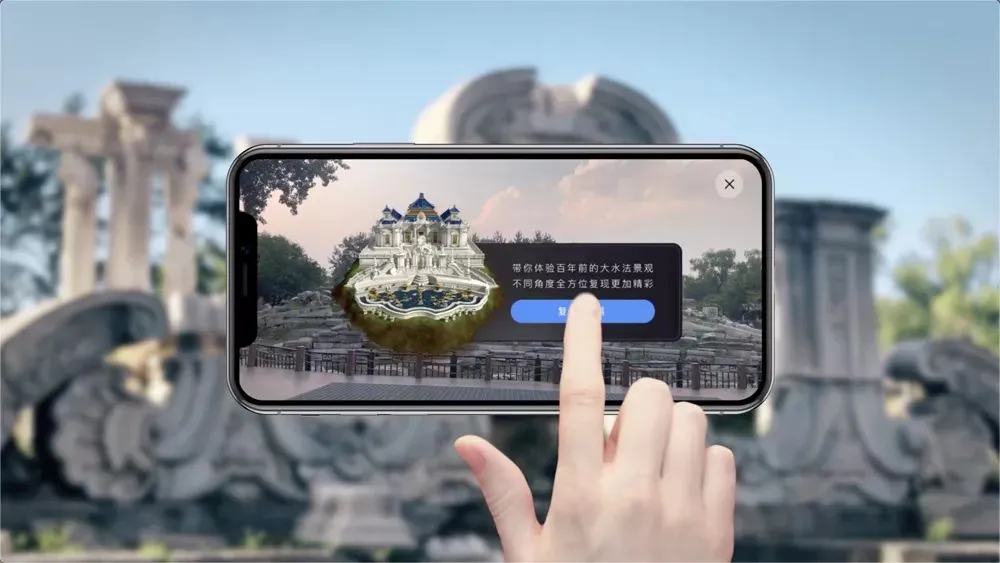 图片展示一只手持智能手机，手机屏幕上通过增强现实技术显示了一座古建筑的三维图像。