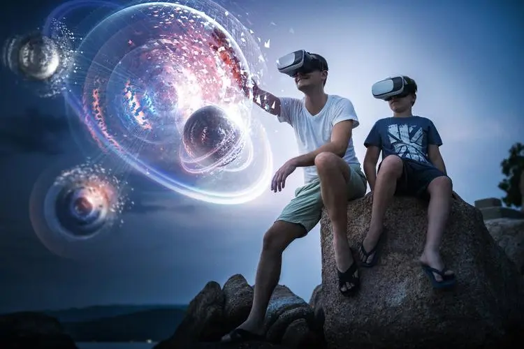 图片中两人戴着虚拟现实头盔，坐在岩石上，面前出现太空和星球的幻想画面，仿佛在体验宇宙旅行。
