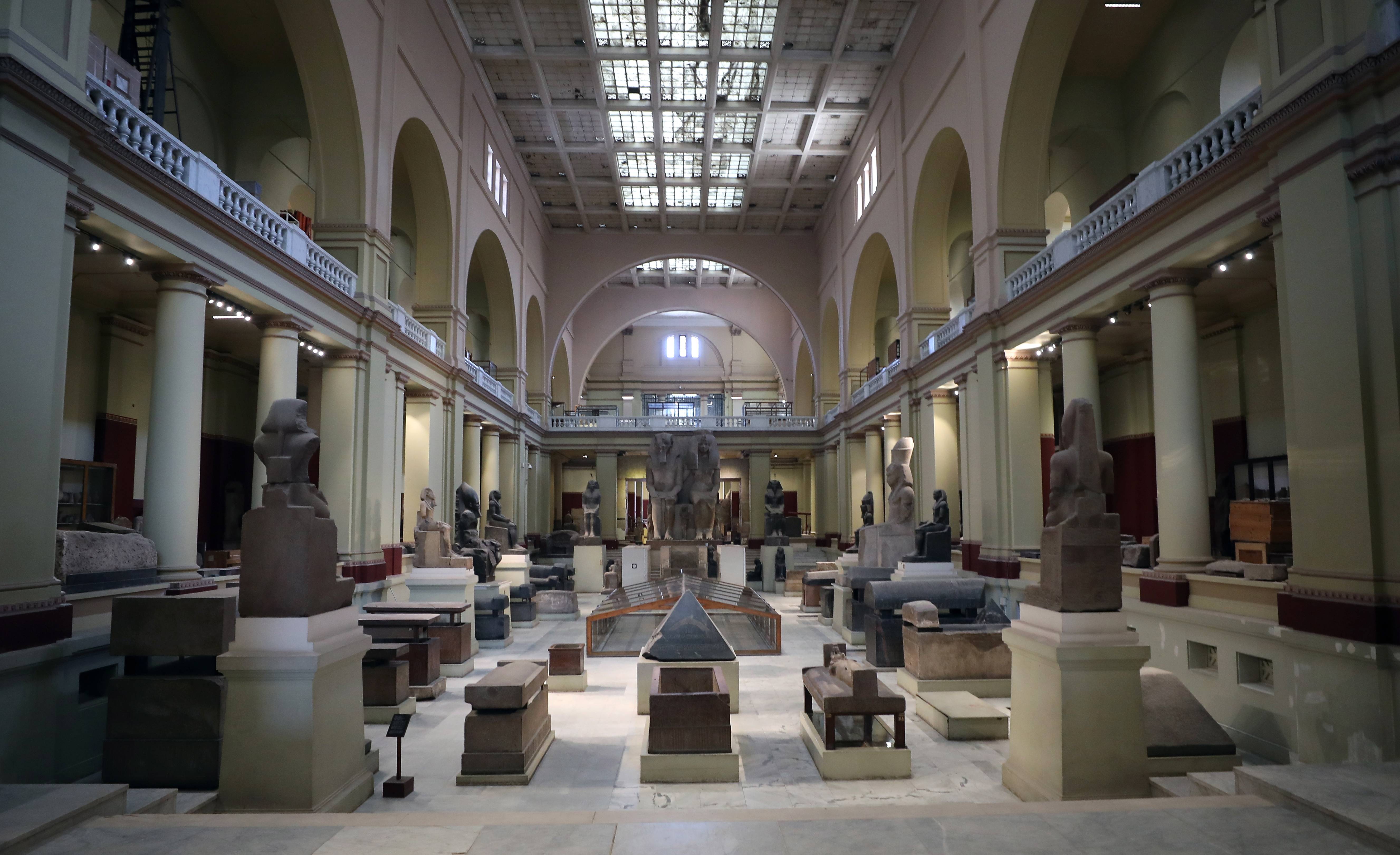 图片展示了一个宽敞的博物馆展厅，内有多件古代雕塑和艺术品，两侧是高大的柱子，顶部是透光天窗。